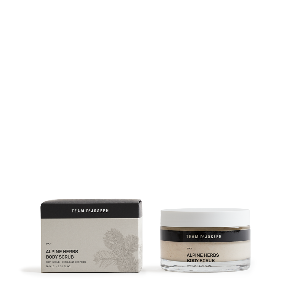 Kaksi kosmetiikkapurkkia, joissa lukee Alpine Herbs Body Scrub, musta ja valkoinen pakkaus taustalla.